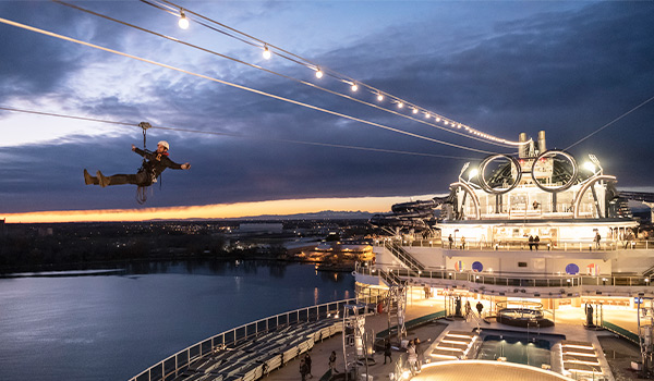 Personne glissant en tyrolienne à travers un navire de croisière durant la nuit