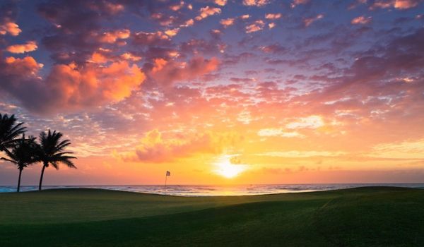 Collines verdoyantes du parcours de golf au coucher du soleil