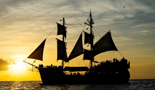 Navire de pirates voguant sur la mer au coucher de soleil