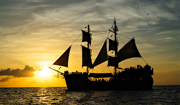 Navire de pirates voguant sur la mer au coucher de soleil