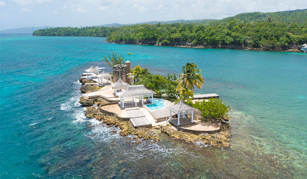 Aerial view of a small private island with a pool and gazebos