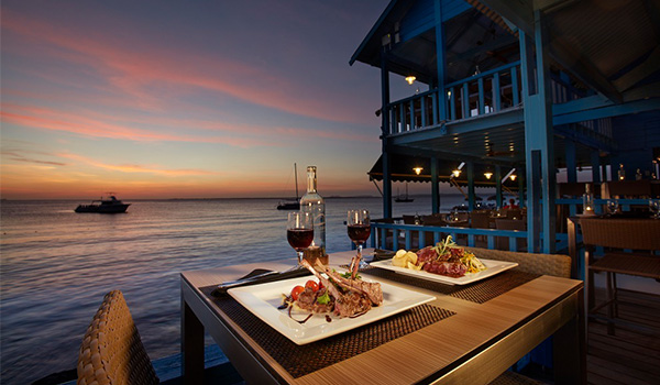 Table for two set up overlooking the water at sunset