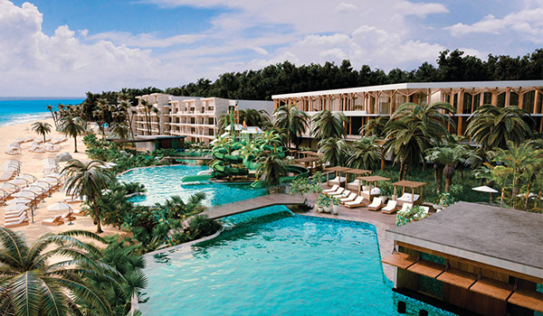 Aerial view of resort pools overlooking the beach surrounded by jungle landscapes