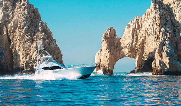 Motor boat cruising past rocky archways