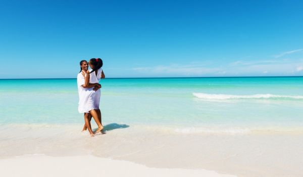 Blue skies, turquoise water, a couple on a white-sand beach