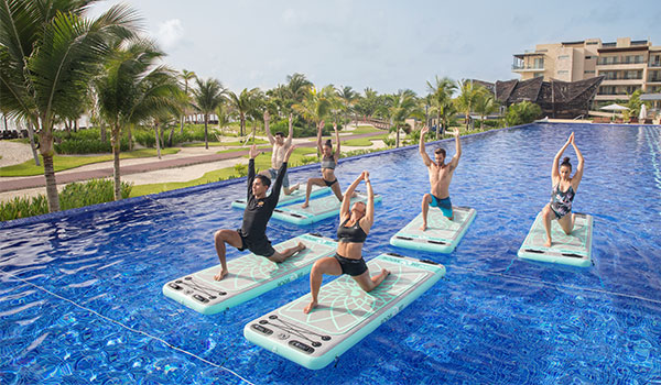 Six people doing a Royalton Fit™ class in the pool.