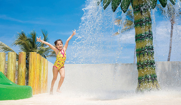 Petite fille qui joue à l’aire de jeux aquatiques du Barceló Huatulco