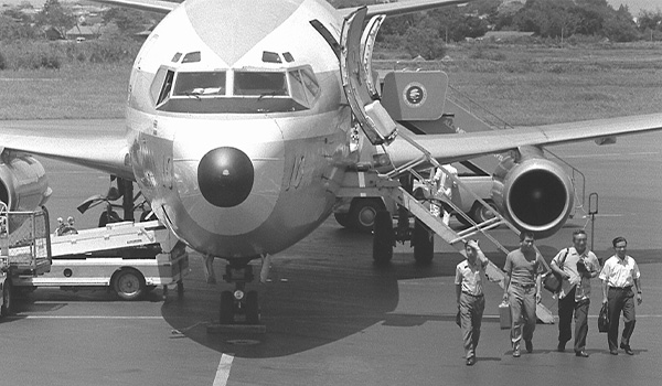 People walking away from an airplane on the runway