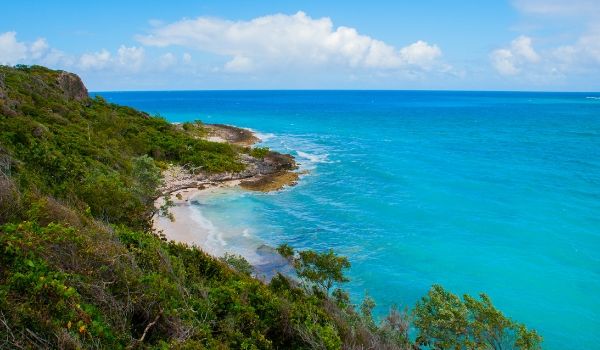 Tropical scenery in Holguin with turquoise waters. white-sand shores and lush green forests