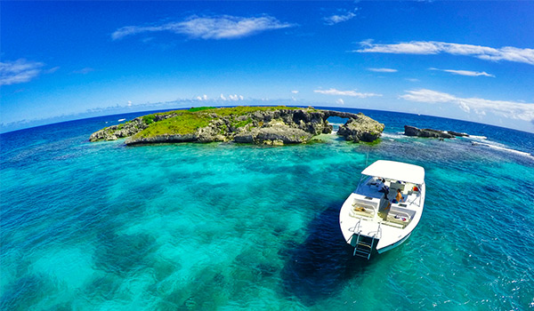 Boat cruising along bright turquoise waters towards a small island