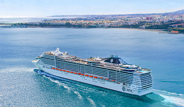Bateau de croisière naviguant près d’une petite île, avec une autre île au loin