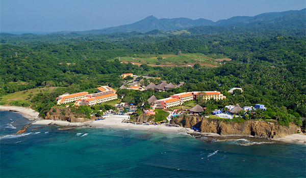 Aerial view of cliffside resort with mountains in the distance