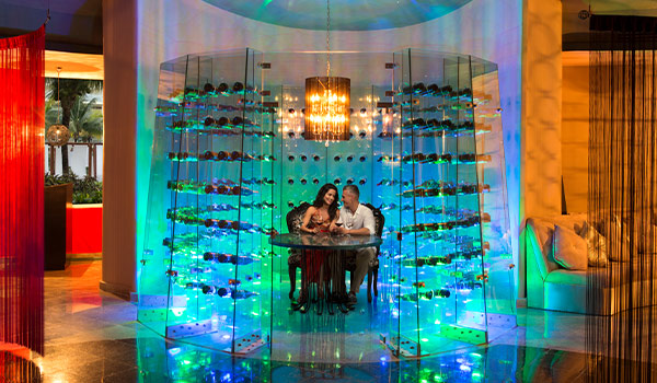 Couple dining in a lit-up romantic wine cellar