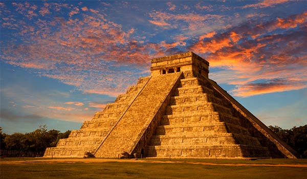 View of Mayan pyramid from the ground at sunset