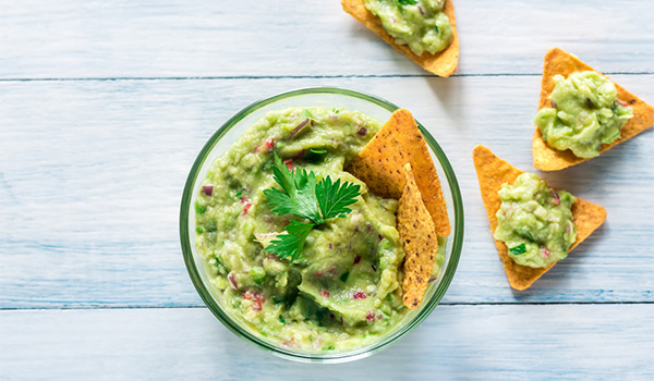 Vue de dessus d'un bol de guacamole avec chips tortilla