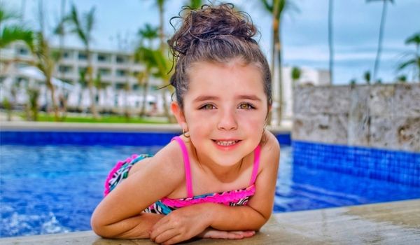 Young girl hanging out by sparkling pool