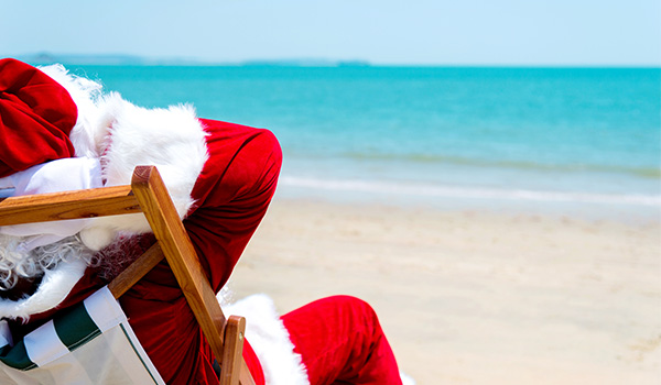 Santa Claus resting on a beach chair overlooking the ocean