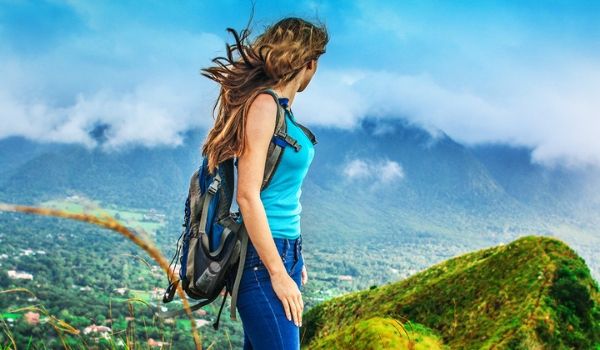 Woman wearing a backpack overlooking lush landscapes