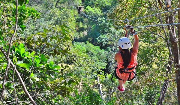 Vacancière faisant de la tyrolienne au-dessus des arbres
