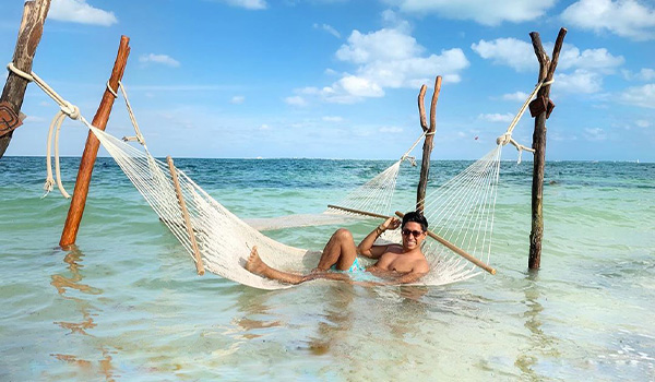 Man lounging on an overwater hammock