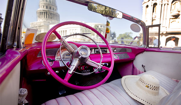 Inside a classic American car with Havana's historic buildings in the background