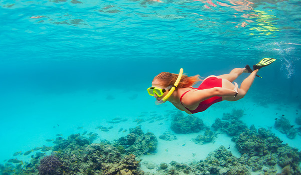 Jeune femme faisant de la plongée avec tuba avec une étoile de mer