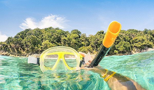 Masque de plongée avec tuba dans une eau cristalline