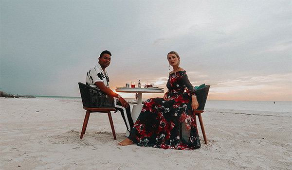 Man and woman sitting at a table on a secluded beach