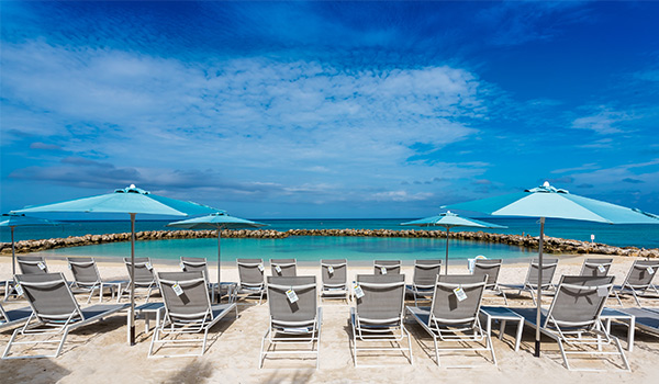 White-sand beach lined with lounge chairs and umbrellas
