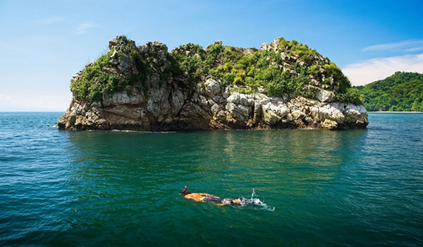 Person snorkelling in front of an island