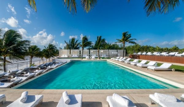 Pool overlooking the beach surrounded by lavish loungers