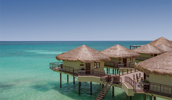 Charming bungalows sitting over the crystal-clear waters of the Caribbean Sea