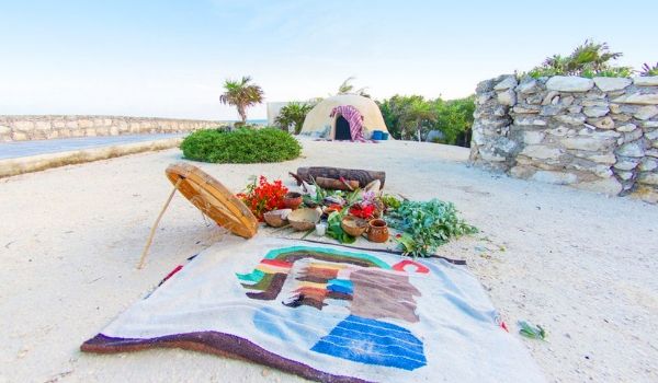 Towel, plants and herbs for a traditional spa treatment laid out on beach