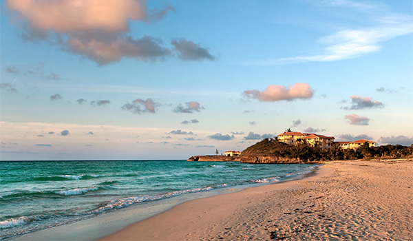 Beach at sunset with a resort in the distance