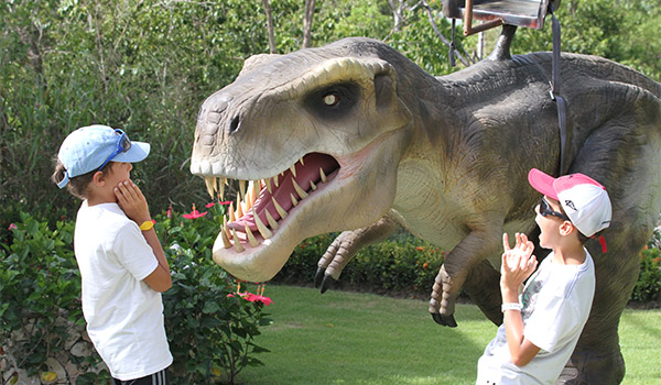 Deux enfants à côté d’un Tyrannosaure Rex anamatronique
