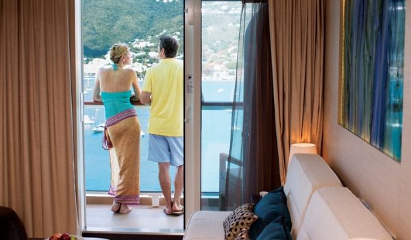 Couple se tenant sur le balcon de leur cabine avec vue sur la mer