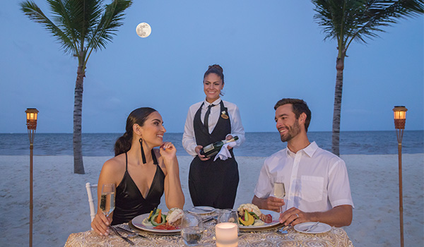 Couple portant un toast avec des coupes de vin en regardant la plage