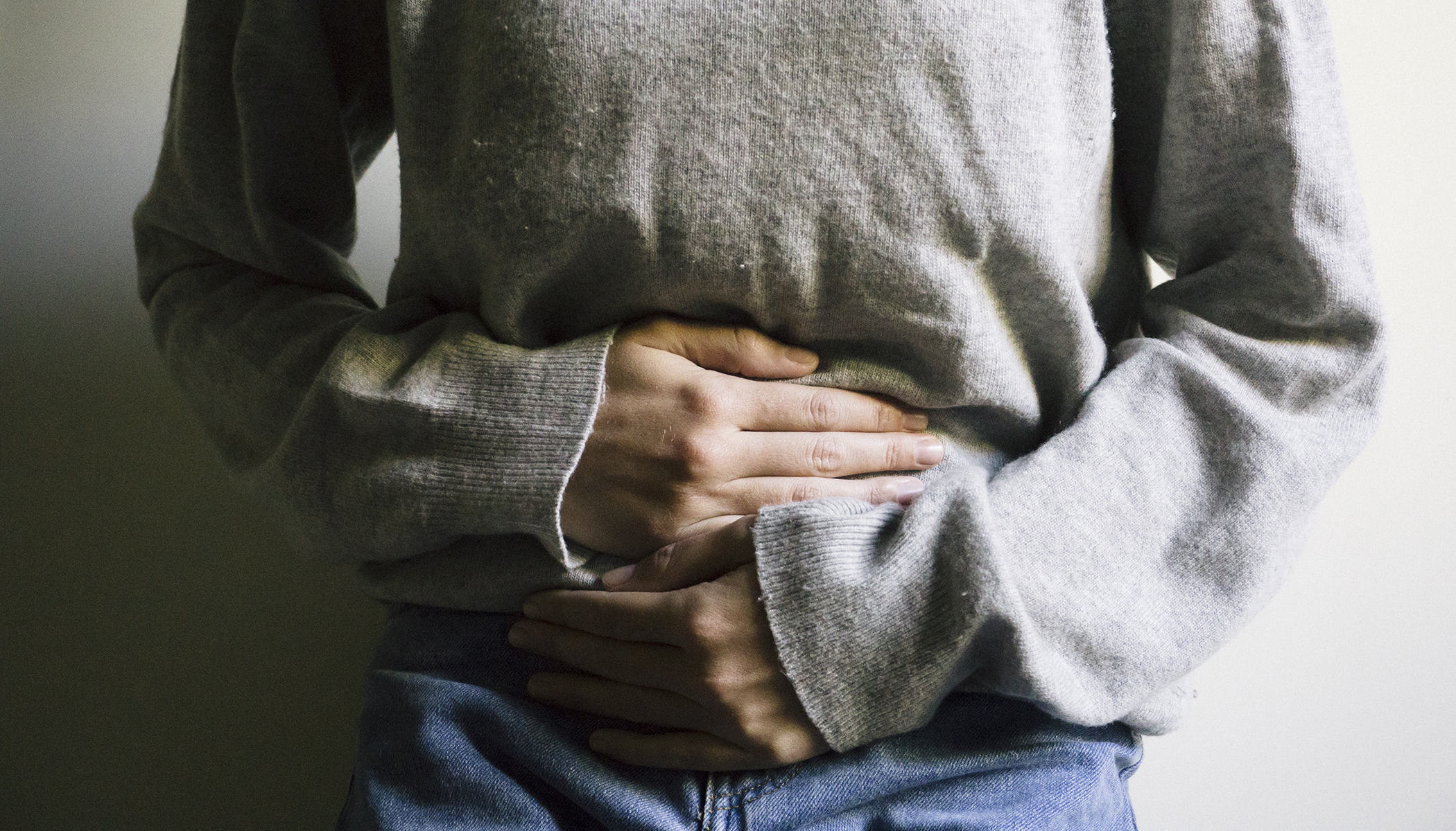 visuel d'une femme qui souffre de syndrome prémenstruel et qui se tient le ventre.