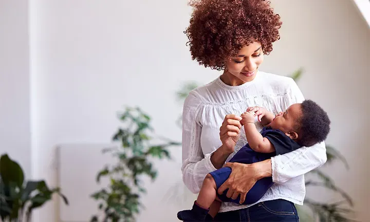 Banner Image of Mom Carrying Baby Boy for Article on Ringworm in Babies & Toddlers