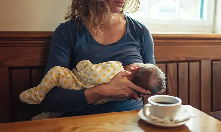 Banner image of a mother breastfeeding her baby for the article can you drink coffee while breastfeeding