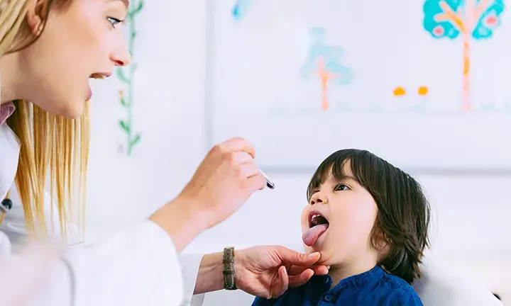 Banner image of a toddler receiving a medical check-up for strep throat