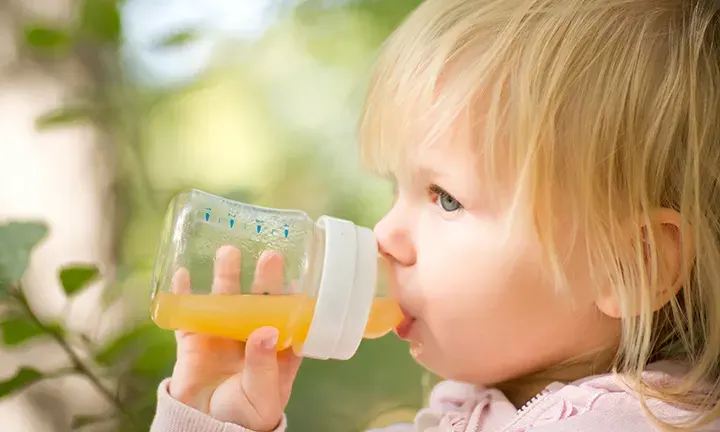 Banner image of a baby having fruit juice for the article -When Can Babies Have Fruit Juice?