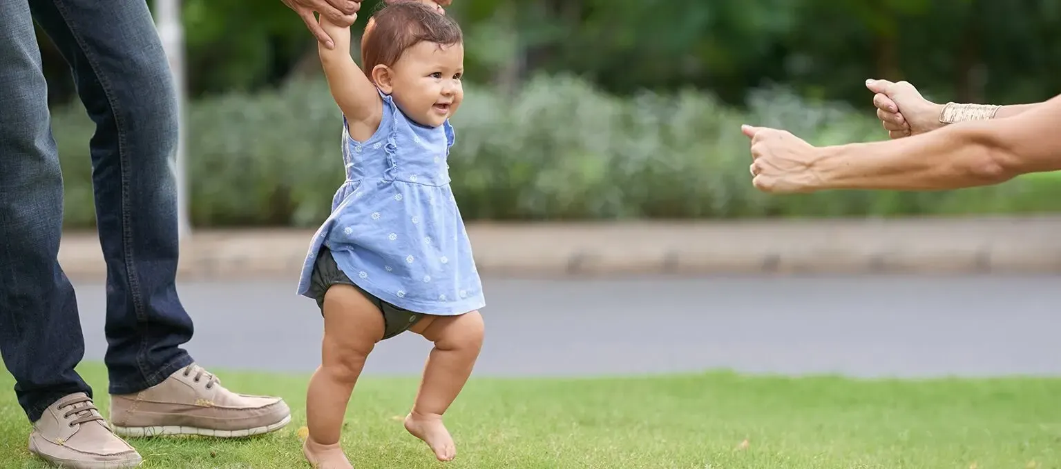 Baby playing in the park with parents