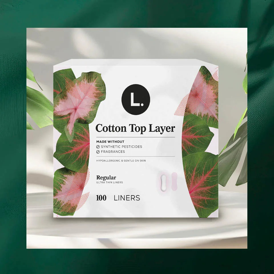 L. Cotton Top Layer liners box surrounded by leaves, emphasizing plant-based, fragrance-free, and hypoallergenic features.