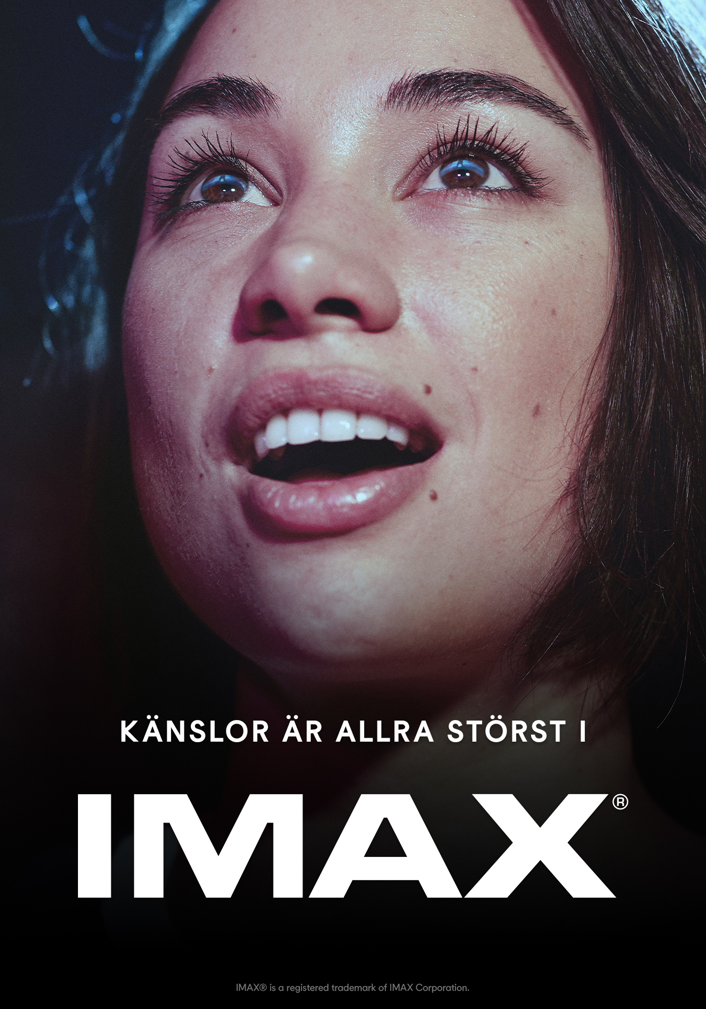 Närbild av ett ansikte upplyst i svala blå toner mot en mörk bakgrund, med blicken riktad uppåt. Nederst i bilden syns texten “Känslor är allra störst i IMAX” samt IMAX-logotypen.