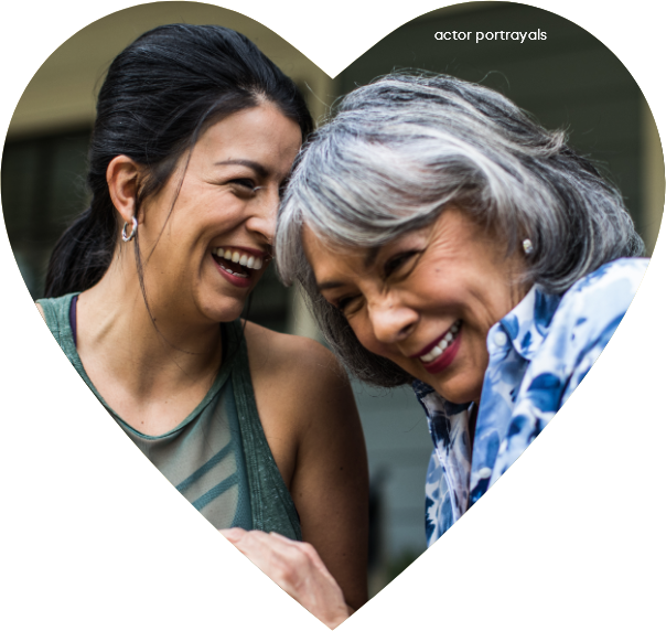 Actor portrayals of 2 women laughing inside of a heart shape