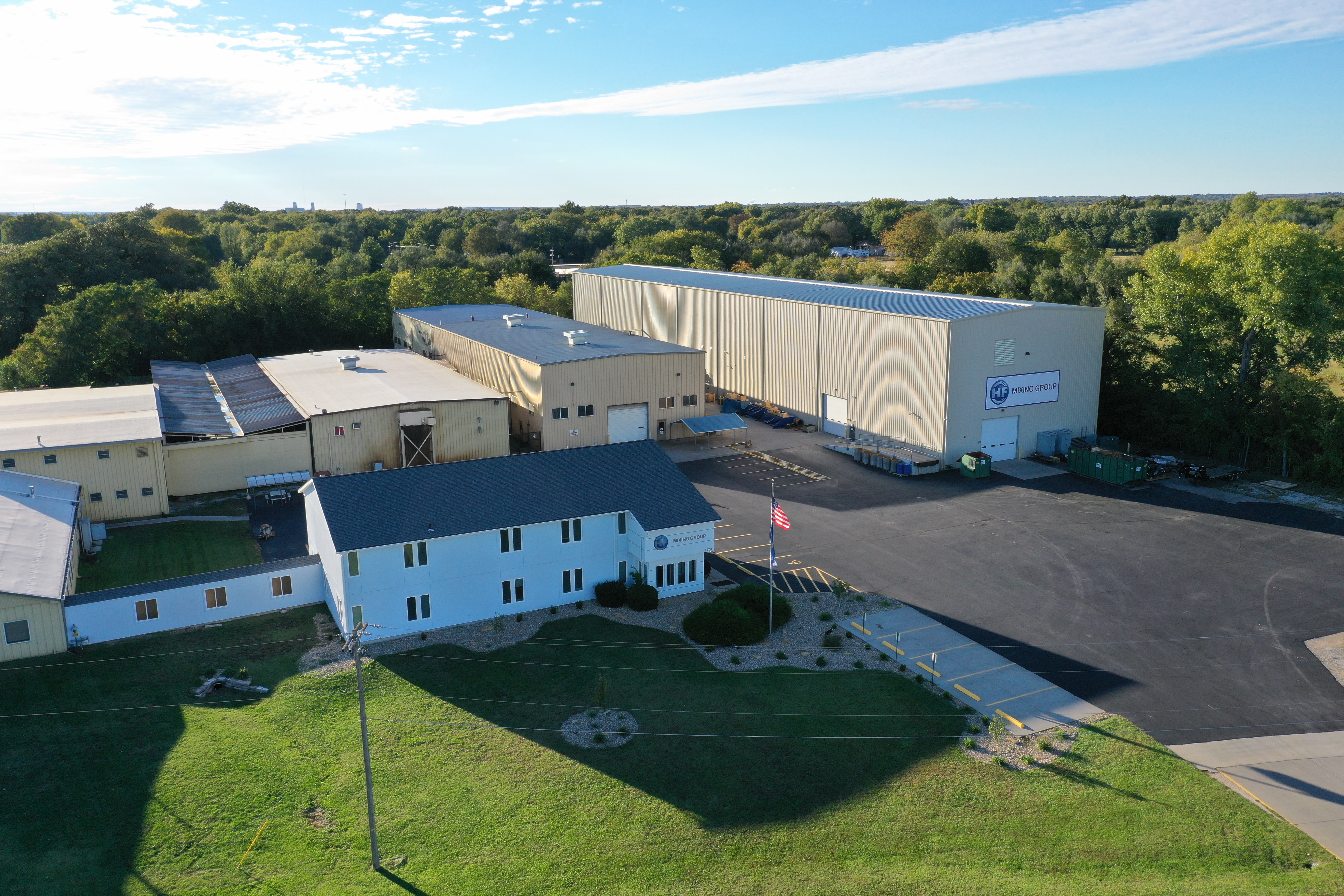 alt="Aerial view of the HF Group company building with adjacent production halls, surrounded by trees and green areas"