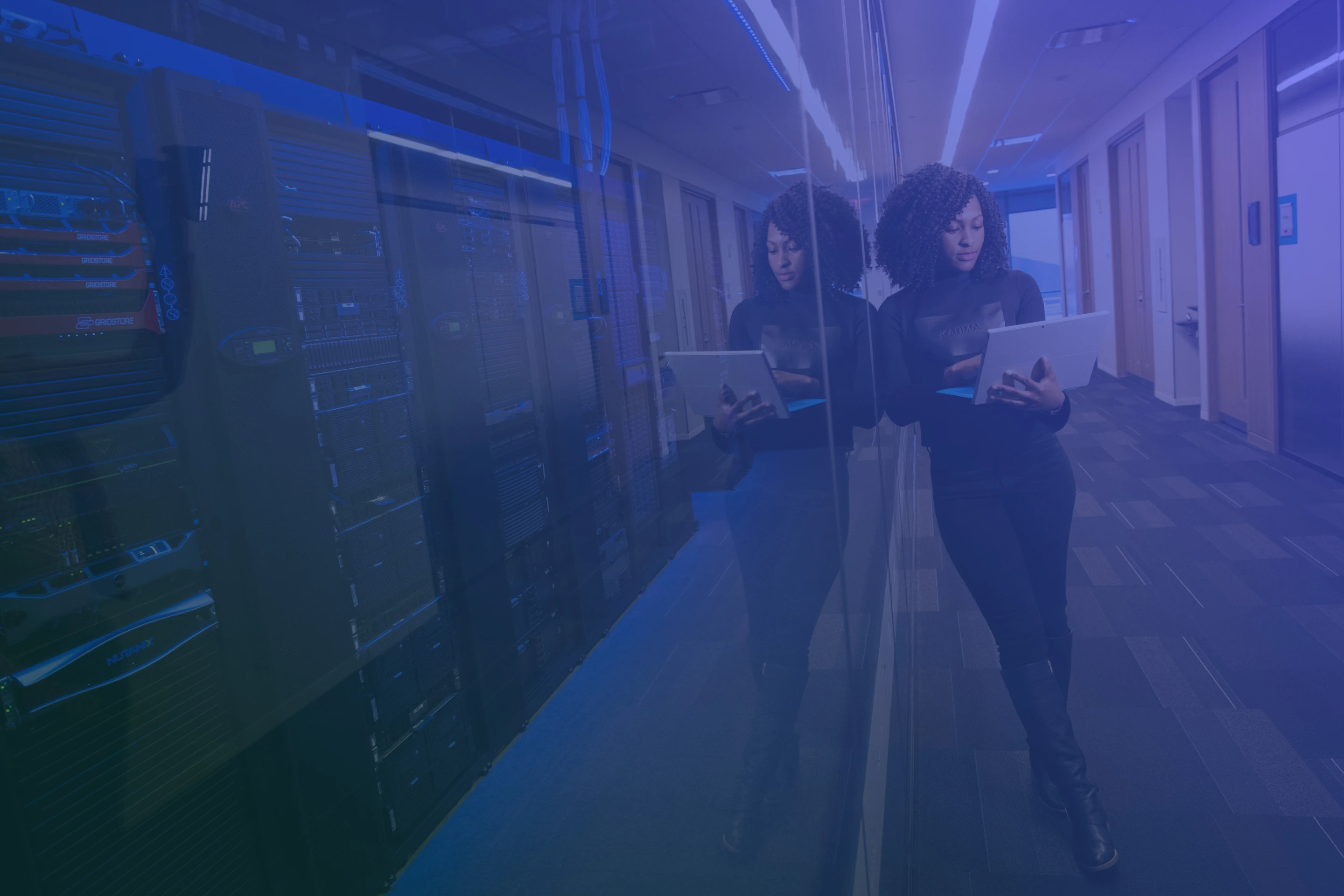 Gradient background featuring a professional IT woman in expansive office space holding a laptop