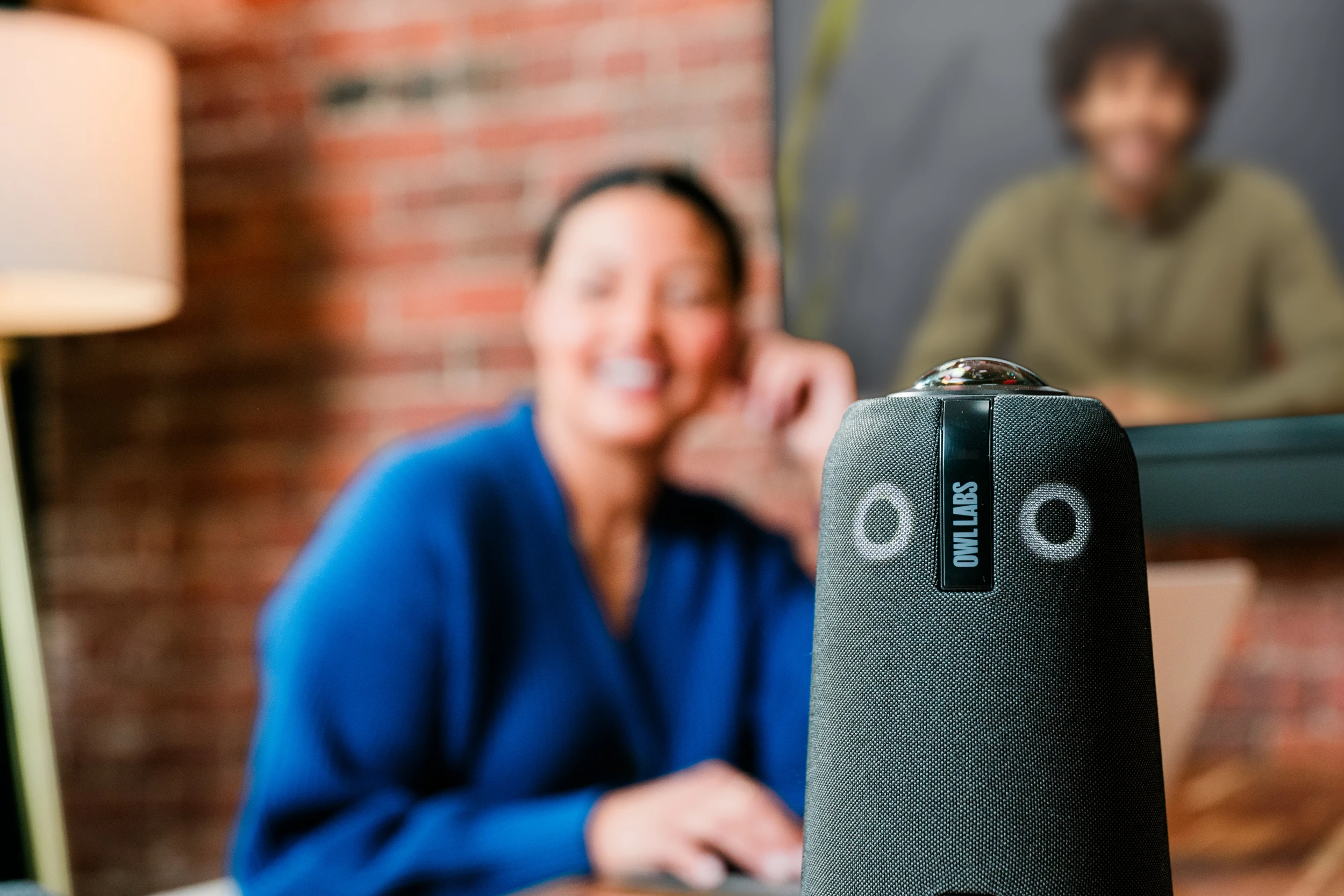 Meeting Owl in clear view with hybrid meeting participants in background
