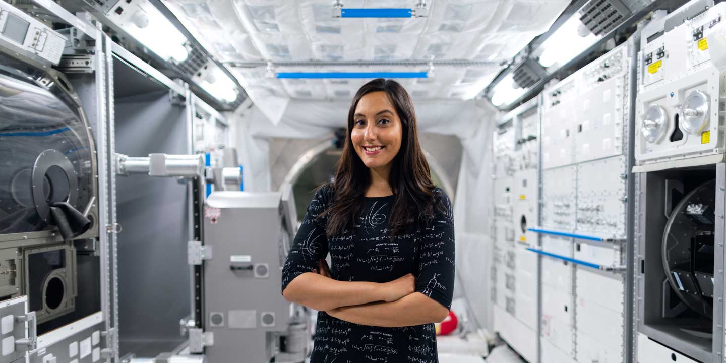 Photo of a woman standing in front of lab equipment by ThisIsEngineering Raeng via Unsplash